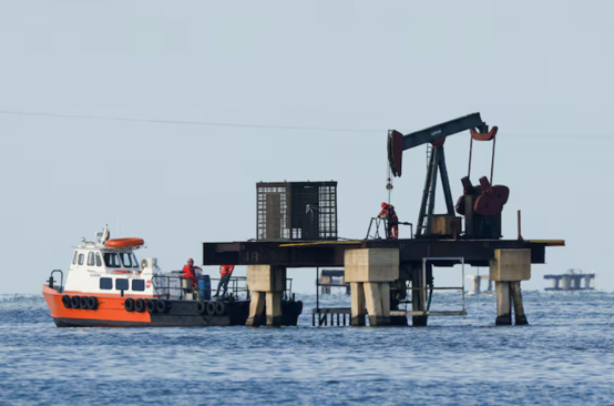 Offshore oil drilling rig and supply vessel, representing the global energy market and U.S. Strategic Petroleum Reserve